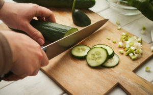 Person slicing cucumber