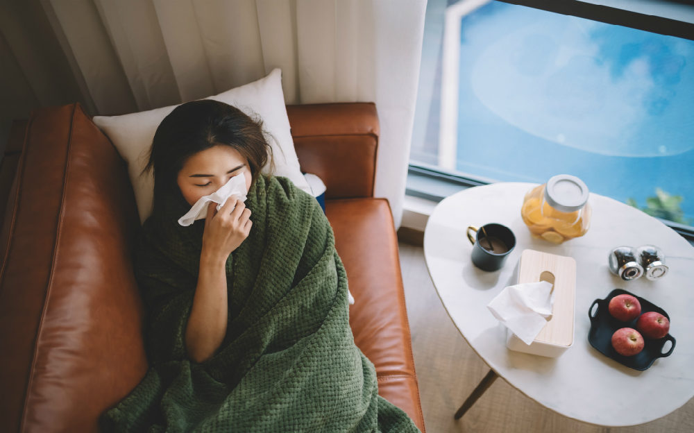 sick woman with flu laying on couch