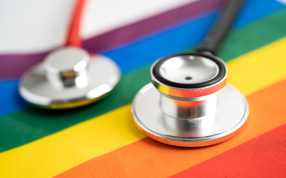 A close up image of a stethoscope on a rainbow flag to represent LGBT medical professionals